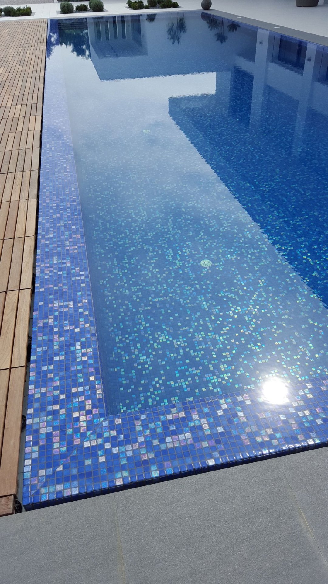 Pool with iridescent mosaic waterline and timber deck